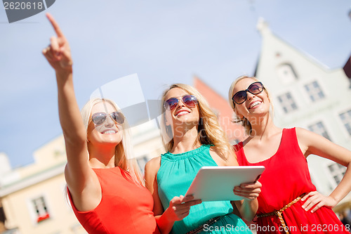 Image of beautiful girls toursits looking into tablet pc