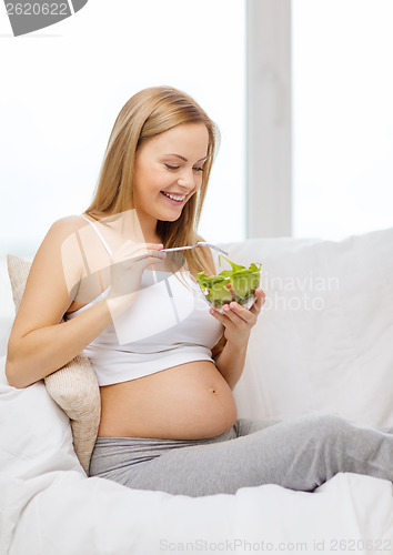 Image of happy pregnant woman eating salad