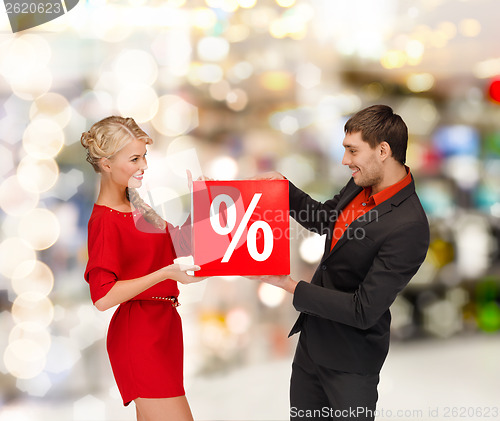 Image of smiling woman and man with red percent sale sign