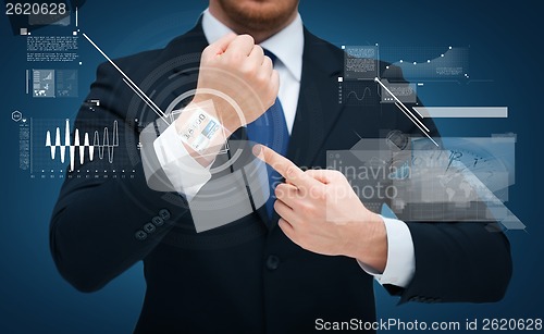 Image of businessman pointing to something at his hand