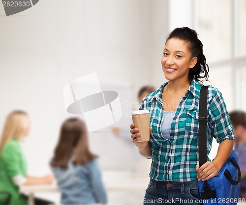 Image of smiling student with bag and take away coffee cup