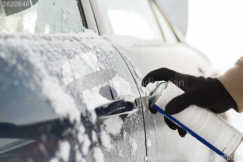 Image of closeup of man hand with lock door de-icer