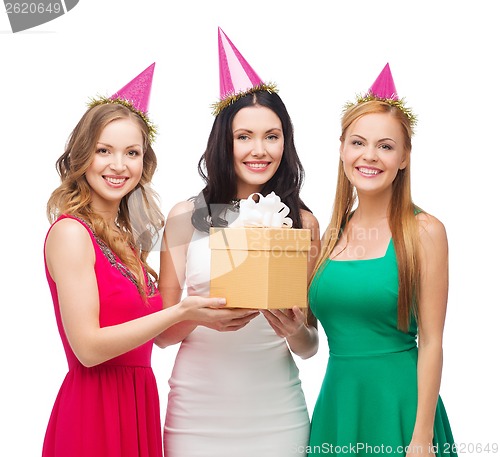 Image of three smiling women in blue hats with gift box