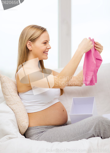 Image of smiling pregnant woman opening gift box