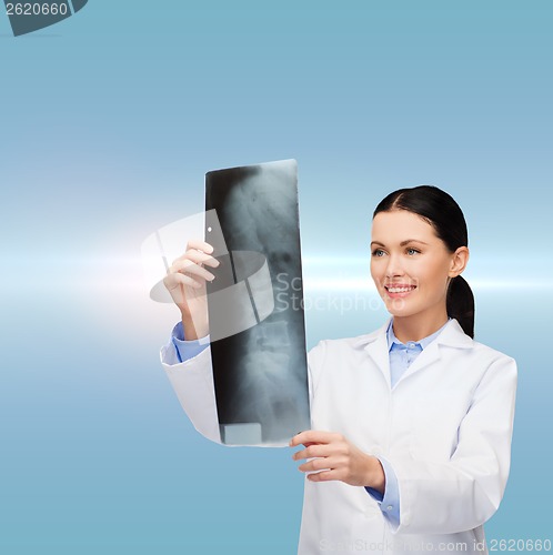 Image of smiling female doctor looking at x-ray