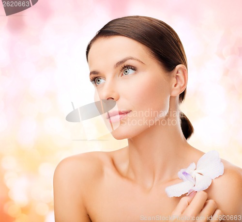 Image of relaxed woman with orhid flower