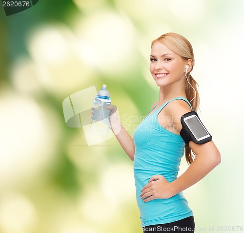 Image of sporty woman running with smartphone and earphones