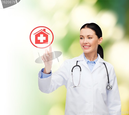 Image of smiling female doctor pointing to hospital sign