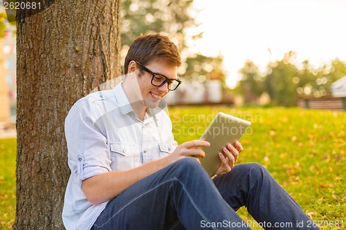 Image of smiling male student in eyeglasses with tablet pc