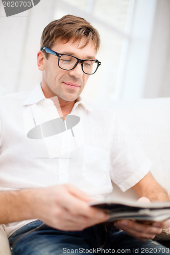 Image of man with magazine at home