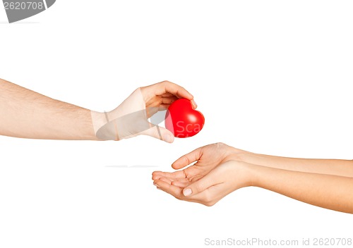 Image of man hand giving red heart to woman