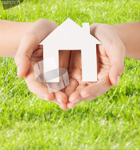 Image of female hands holding paper house