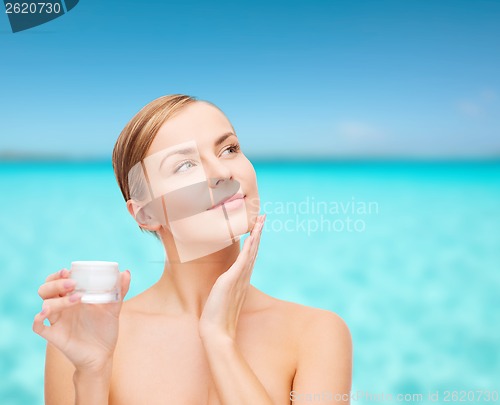 Image of woman applying cream on her skin