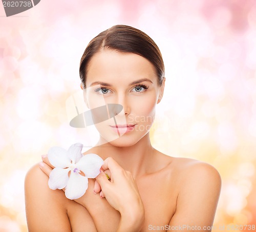 Image of relaxed woman with orhid flower