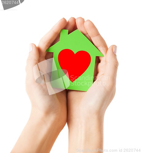 Image of hands holding green paper house