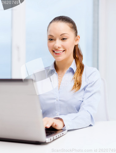 Image of smiling businesswoman with laptop in office