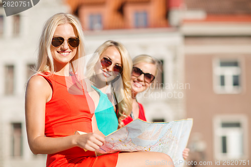 Image of beautiful three women with tourist map in the city