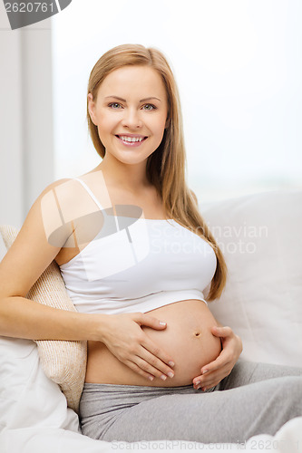 Image of happy pregnant woman touching her belly