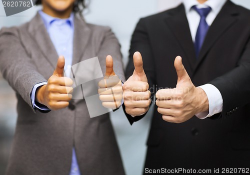 Image of businessman and businesswoman showing thumbs up
