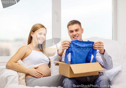 Image of happy family expecting child opening parcel box