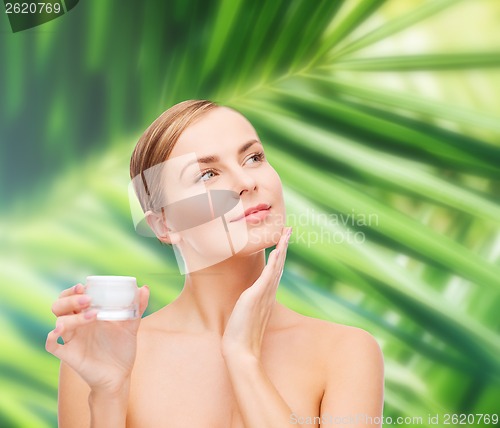 Image of woman applying cream on her skin