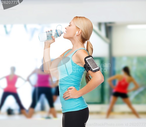 Image of sporty woman running with smartphone and earphones