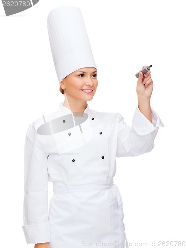 Image of smiling female chef writing something on air