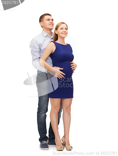 Image of happy young family expecting child looking up