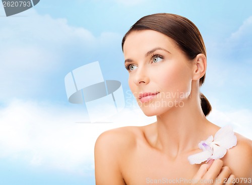 Image of relaxed woman with orhid flower