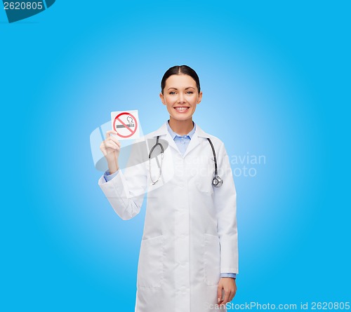 Image of smiling female doctor holding no smoking sign