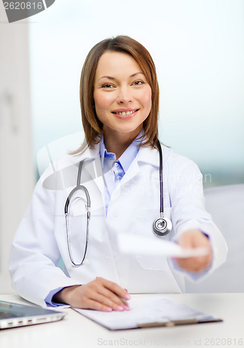 Image of smiling doctor with laptop computer and clipboard