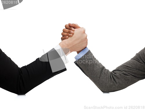 Image of businessman and businesswoman wretsling on table