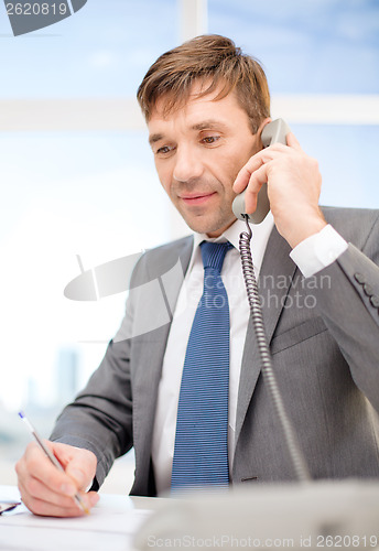 Image of businessman with phone and documents