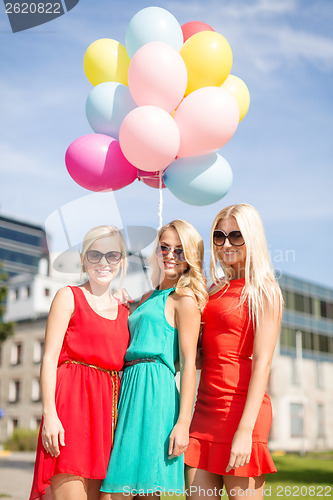 Image of beautiful girls with colorful balloons in the city