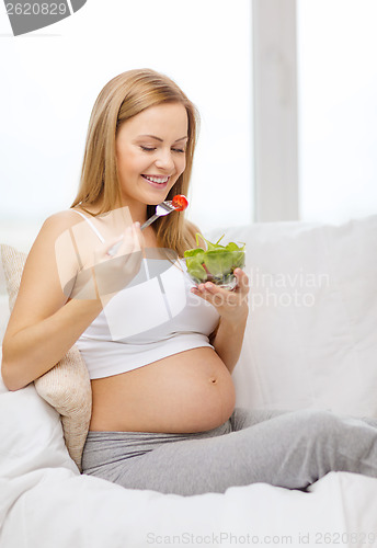 Image of happy pregnant woman eating salad