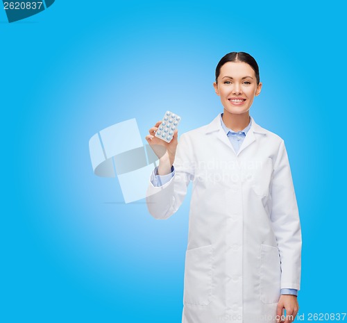 Image of smiling female doctor with pills