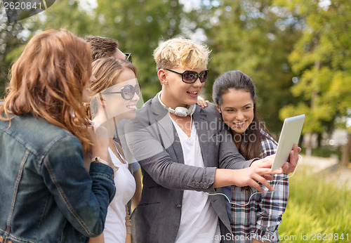 Image of teenagers taking photo with tablet pc outside