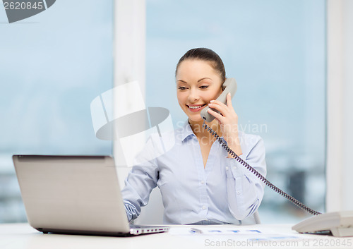 Image of businesswoman with phone, laptop and files