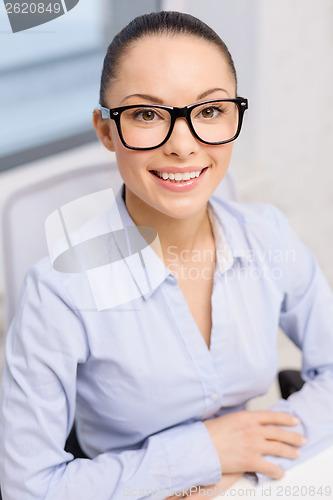 Image of smiling businesswoman in eyeglasses in office