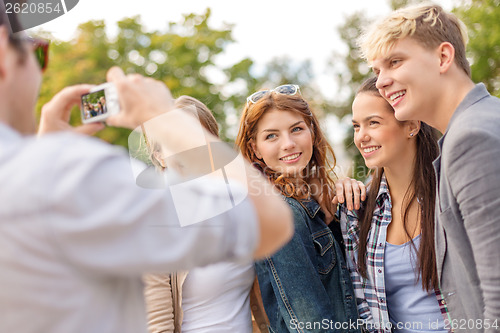 Image of teenagers taking photo digital camera outside