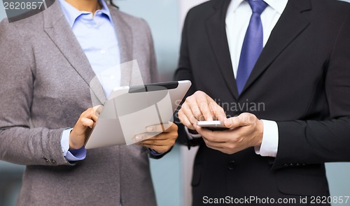 Image of two businesspeople with smartphone and tablet pc