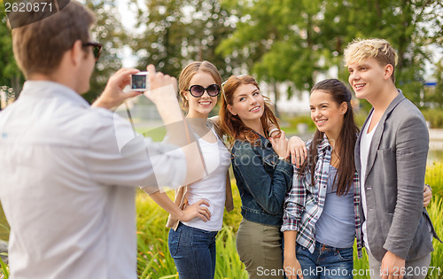 Image of teenagers taking photo digital camera outside