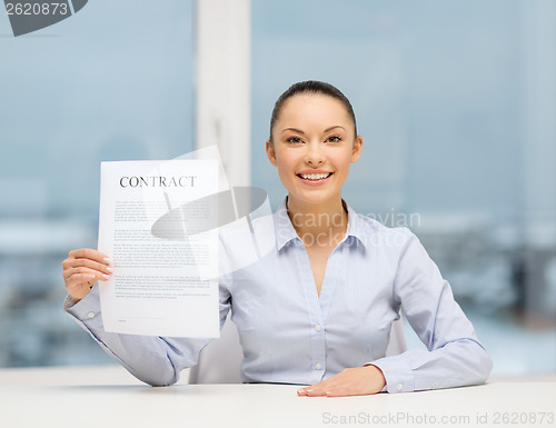 Image of happy businesswoman holding contract in office