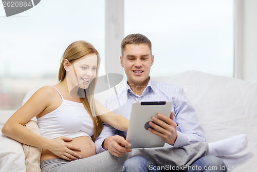 Image of expecting family with tablet pc computer