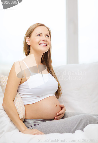 Image of happy pregnant woman touching her belly