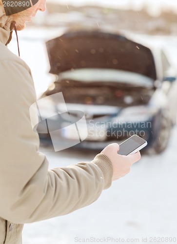 Image of closeup of man with broken car and cell phone