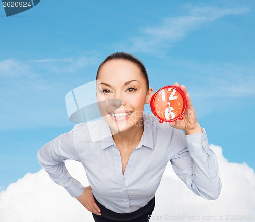 Image of smiling businesswoman with red clock