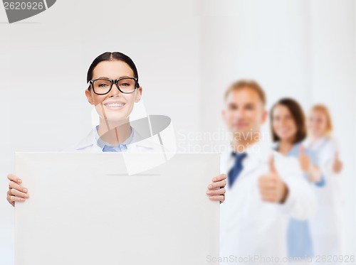 Image of female doctor in eyeglasses with white blank board