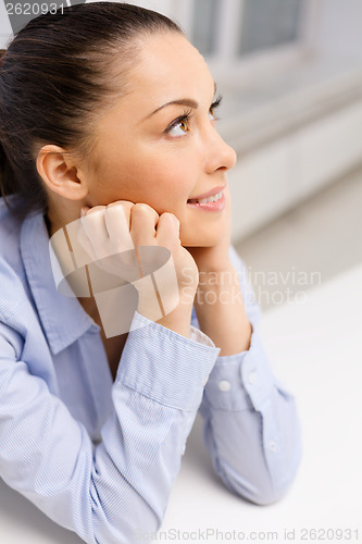 Image of smiling businesswoman dreaming in office