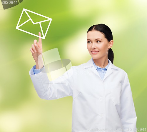 Image of smiling female doctor pointing to envelope